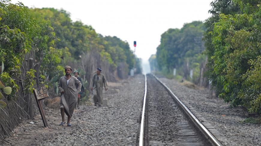 Mango farms workers walk on a railway after the end of their working day in the al-Qata village, Giza Governorate, on August 27, 2018. (Photo by Mohamed el-Shahed / AFP) (Photo credit should read MOHAMED EL-SHAHED/AFP via Getty Images)