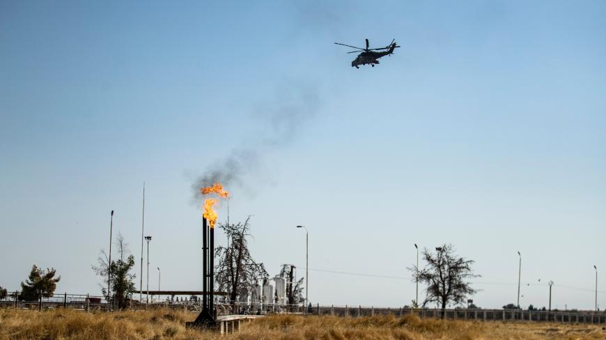 A Russian army helicopter, part of a patrol, flies over an oil field in the countryside of al-Qahtaniyah town in Syria's northeastern Hasakah province near the Turkish border, on Oct. 11, 2020.