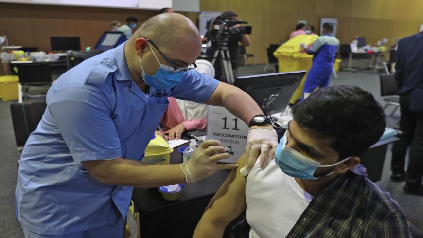 A man receives a dose of the coronavirus vaccine at the Qatar National Convention Center, Doha, Qatar, Feb. 18, 2021.