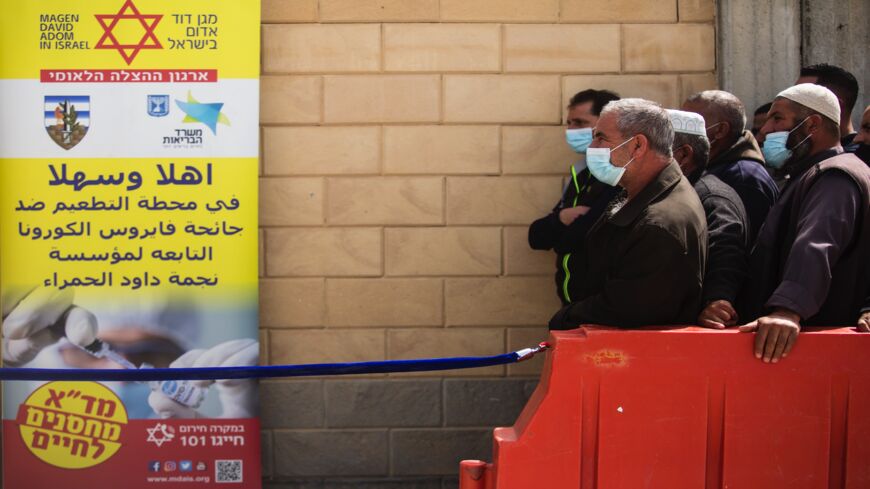 Palestinians who work in Israel wait in line to receive the first dose of a Moderna COVID-19 vaccine by Israeli medical workers in Meitar crossing checkpoint between the West Bank and Israel on March 9, 2021 in Meitar, Israel. More than two months after starting a world-leading COVID-19 vaccination campaign for its own citizens, Israel began administering the Moderna vaccine to Palestinian laborers from the West Bank who enter Israel or Israeli settlements for work. 