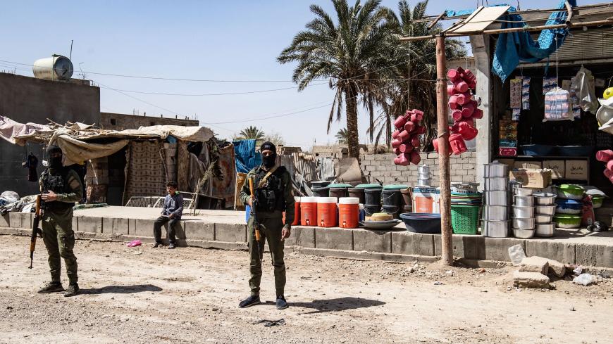 Fighters of the Kurdish-led Syrian Democratic Forces (SDF) stand guard in the village of Baghouz in Syria's northern Deir Ezzor province, on March 24, 2021,