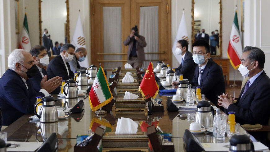 Iranian Foreign Minister Mohammad Javad Zarif (L) meets with his Chinese counterpart Wang Yi (R), in the capital Tehran, on March 27, 2021. - Iran and China signed what state television called a "25-year strategic cooperation pact" on today as the US rivals move closer together. The agreement, which has been kept almost entirely under wraps, was signed by the two countries' foreign ministers, Mohammad Javad Zarif and Wang Yi, an AFP correspondent reported.