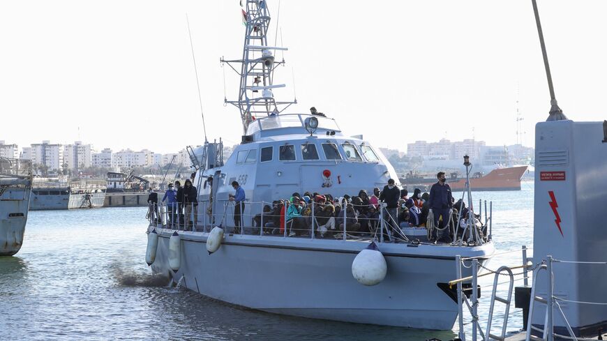 Migrants arrive at a naval base in the Libyan capital of Tripoli