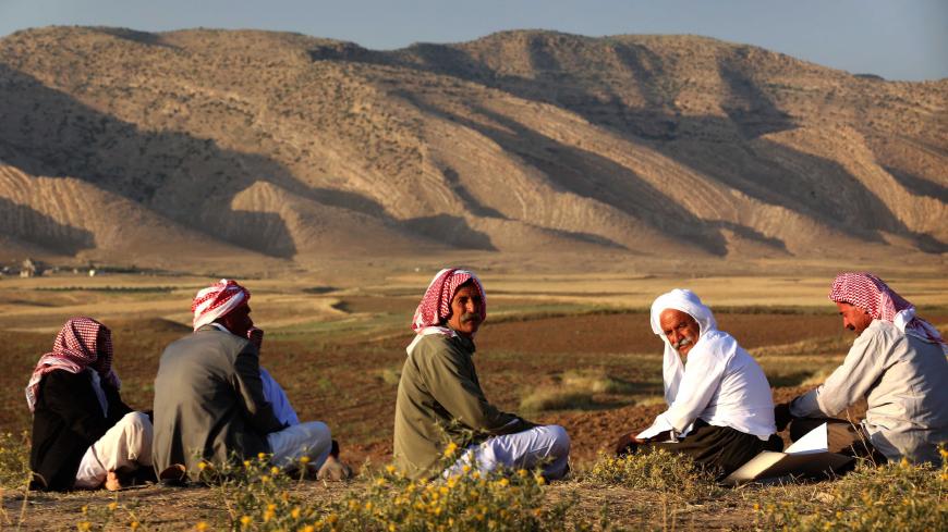 Displaced Iraqis from the Yazidi community, who fled violence between Islamic State (IS) group jihadists and Peshmerga fighters in the northern Iraqi town of Sinjar, sit in a field near a camp for internally displaced persons (IDP) in the Sharya area some 15 kilometres from the northern Iraqi city of Dohuk on May 20, 2015. 