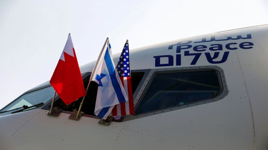 The Bahraini, Israeli and US flags are pictured attached to the Boeing 737 aircraft of Israel's El Al, adorned with the word "peace" in Arabic, English and Hebrew, ahead of the flight to Bahrain's capital, Manama, at Israel's Ben Gurion Airport near Tel Aviv on Oct. 18, 2020.