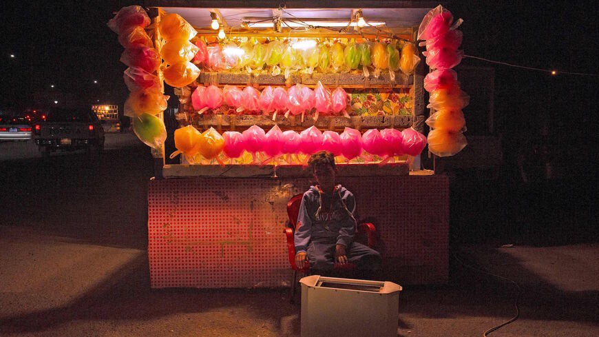 An Iraqi boy sells cotton candy by the Shatt Al-Arab River in the southern Iraqi city of Basra, Nov. 14, 2020.