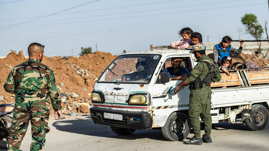 Members of the Syrian Kurdish internal security services known as Asayish and Syrian government forces man a joint checkpoint in the Tayy neighborhood in Qamishli, Syria, April 27, 2021.