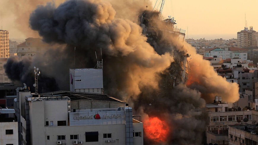 Heavy smoke and fire surround Al-Sharouk tower as it collapses during an Israeli air strike, in Gaza City on May 12, 2021. 