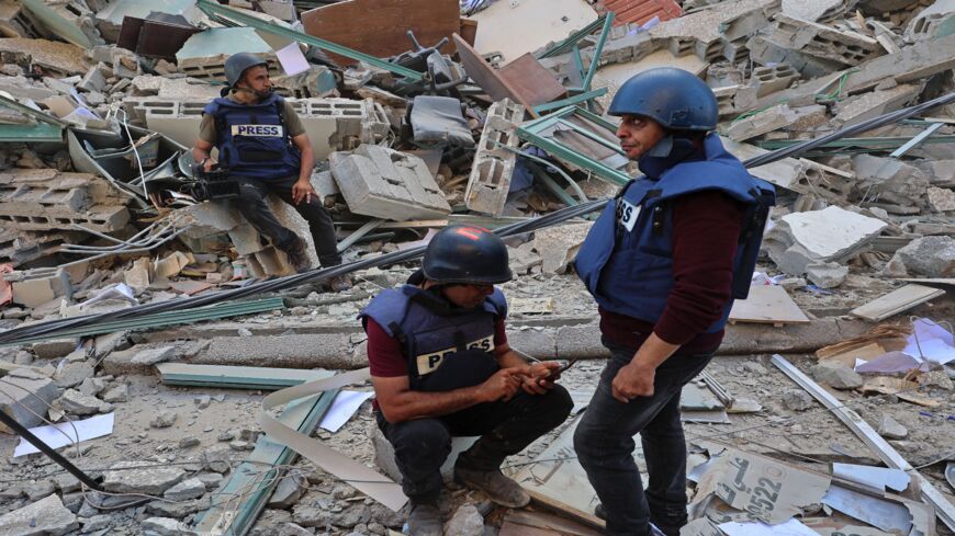 Journalists sit on to the rubble of Jala Tower, which was housing international press offices, following an Israeli airstrike in the Gaza Strip on May 15, 2021. The airstrike demolished the 13-floor building housing Qatar-based Al-Jazeera television and American news agency The Associated Press in the Gaza Strip.