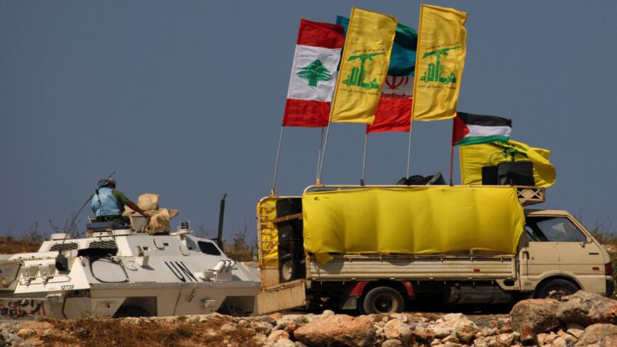 A picture taken on May 20, 2021, from the northern Israeli town of Metula near the border with Lebanon, show people raising Palestinian, Lebanese and Iran-backed Hezbollah flags during a rally in solidarity with the Palestinians, on the outskirts of the southern Lebanese village of Kfarkila, near a United Nations Interim Force in Lebanon (UNIFIL) armored personnel carrier. The Israeli-Palestinian ongoing military conflict has many eyes trained on the Lebanese border for a reaction from the Iran-backed Hezbo