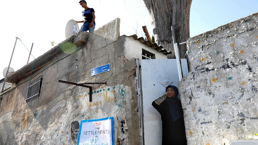 A Palestinian family looks out from their home toward a protest by Israeli, Palestinian and foreign activists, against evictions of Palestinian families from their homes, in the mostly Arab neighborhood of Sheikh Jarrah, East Jerusalem, Aug. 4, 2017.