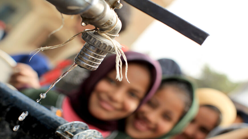 Egyptian girls stand in line at a water cistern to fill their containers with clean water at al-Rahawe village, some 40 kilometers (25 miles) northeast of Cairo, Egypt, May 27, 2010. 