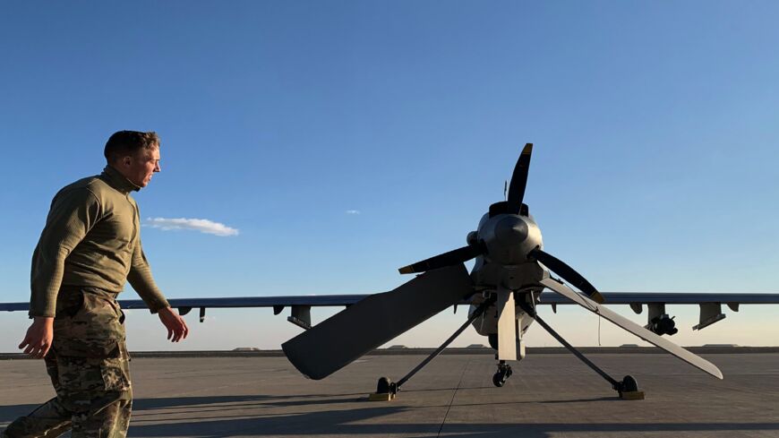 A picture taken on Jan. 13, 2020, during a press tour organized by the US-led coalition fighting the remnants of the Islamic State, shows a US soldier walking past a drone at the Ain al-Asad air base in the western Iraqi province of Anbar. 