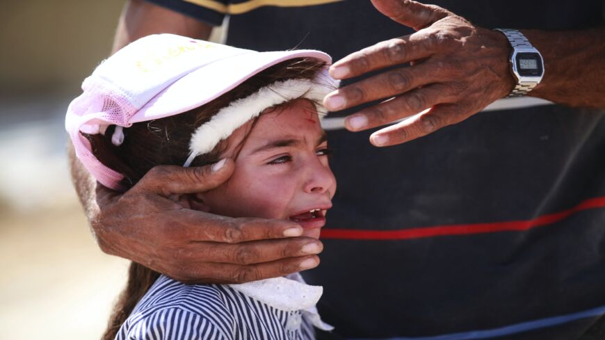 A Palestinian girl cries as Israeli excavators demolish some of the construction belonging to Palestinians for allegedly being unauthorized and being in zone C, at Yatta district in Hebron, West Bank, on Sept. 30, 2020. 