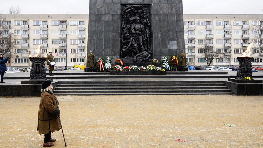 A woman attends a ceremony to commemorate the victims of the Holocaust at the Ghetto Heroes Monument in Warsaw, Poland, on Jan. 27, 2021. 