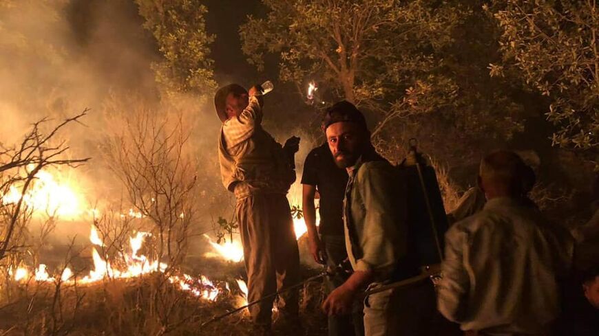 Assyrian villagers of Iraq's Nahla Valley work to put out flames caused by Turkish airstrikes.