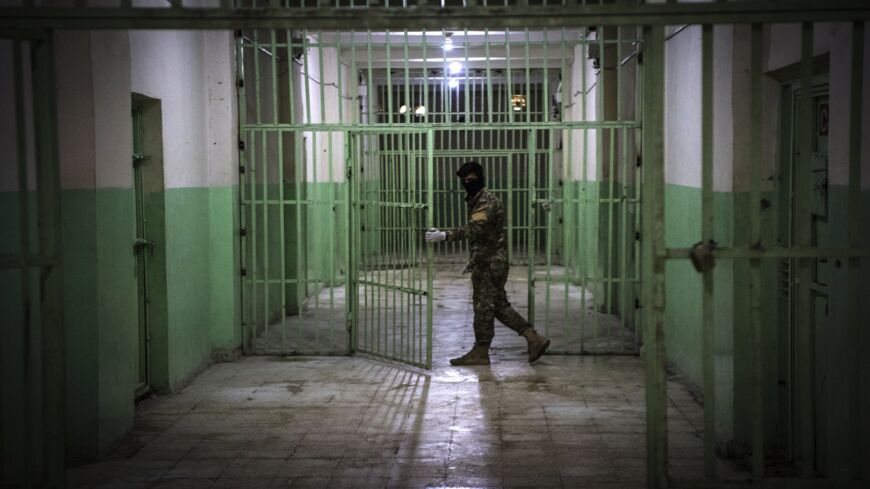 A member of the Syrian Democratic Forces (SDF) stands guard in a prison where men suspected of being affiliated with the Islamic State (IS) group are jailed in northeast Syria in the city of Hasakah on Oct. 26, 2019. 