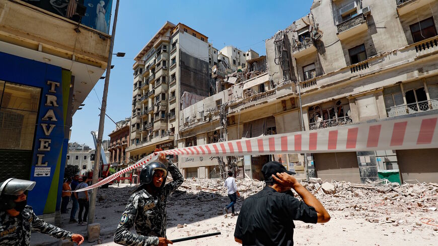 Policemen stand by the rubble at the scene of a building collapse along Kasr el-Nile street in the Egyptian capital Cairo's downtown district, on Aug. 15, 2020. 