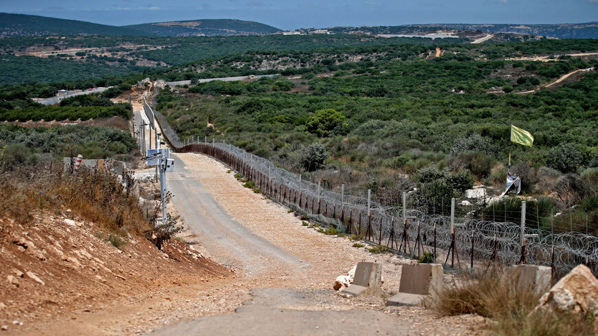 A Hezbollah flag flutters on the Lebanese side of the border fence with Israel, near the northern Israeli settlement of Shtula, July 20, 2021.