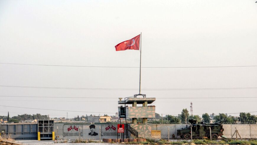 A Turkish military truck patrols next to a Turkish flag hoisted at the border with Syria on Aug. 14, 2019, in Akcakale, in Sanliurfa, southeastern Turkey. 