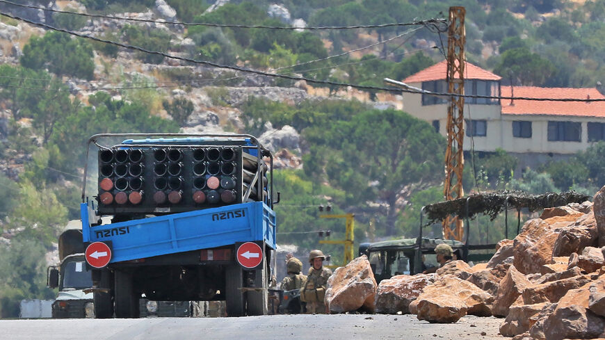 Lebanese soldiers stand next to a truck carrying a multiple rocket launcher after confiscating it