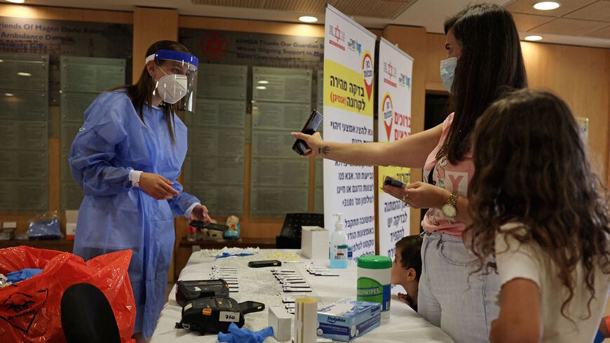 A family arrives for a rapid COVID-19 antigenic test at Israel's Magen David Adom medical service in Jerusalem on Aug. 8, 2021. 