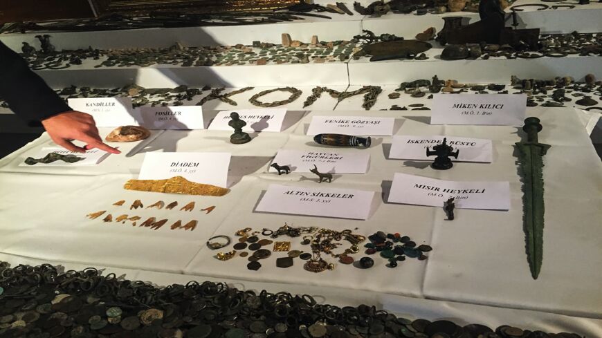 A Turkish police officer points to historical artifacts after police confiscated thousands of historical artifacts in a giant operation against smugglers in Istanbul.