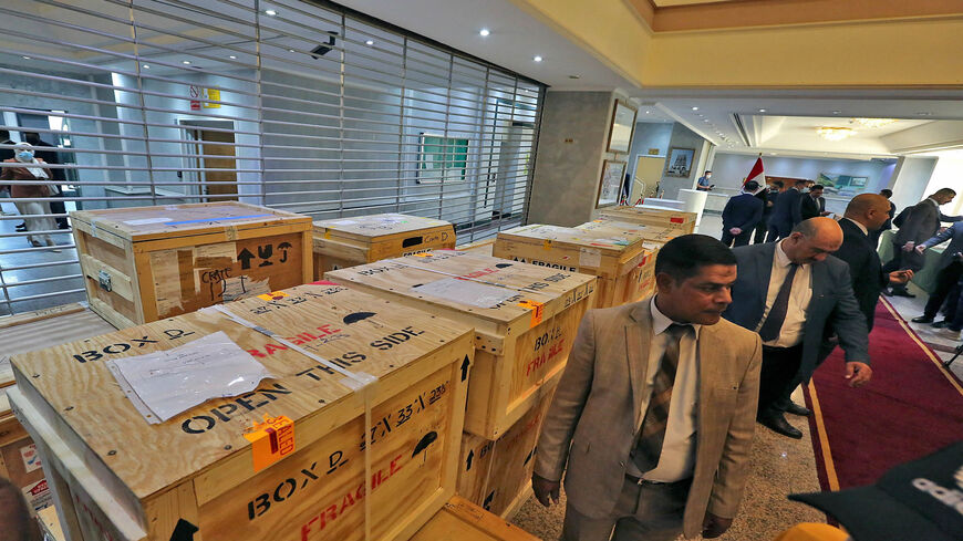 Staff members at the Ministry of Foreign Affairs work around crates of looted Iraqi antiquities returned by the United States, ahead of a handover ceremony at the ministry in Baghdad, Iraq, Aug. 3, 2021.