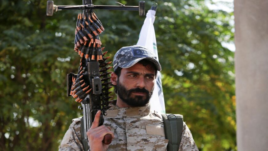 A Syrian fighter with Turkey-backed forces is pictured on a road between the northern Syrian towns of Tell Abyad and Kobani on October 22, 2019.