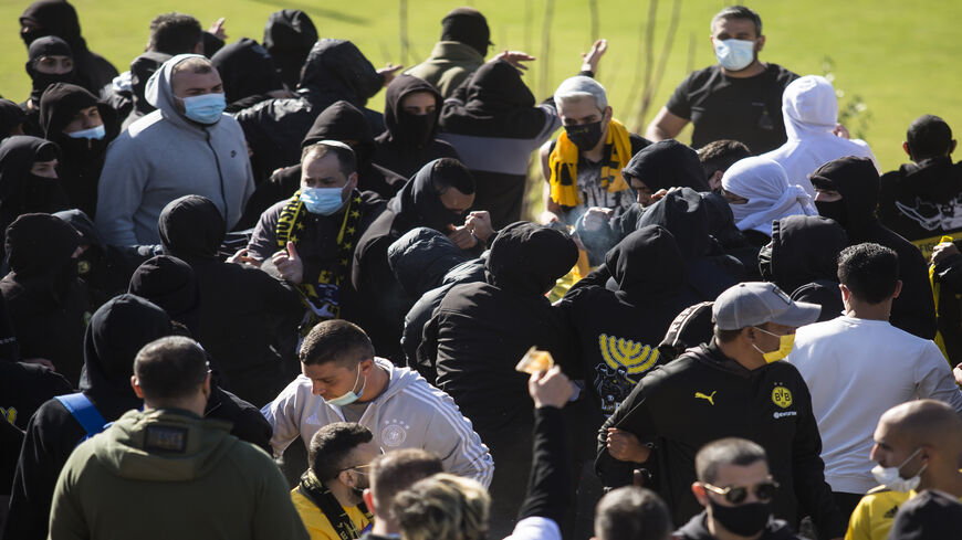 Fans of Beitar Jerusalem soccer club La Familia clash with other team fans during a training session, Jerusalem, Dec. 11, 2020.