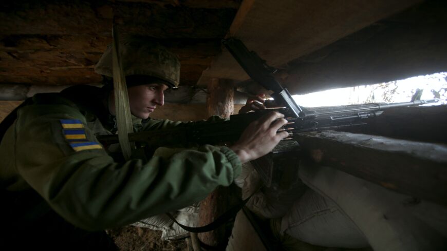 A Ukrainian serviceman loads a machine gun in a dugout on the front line with Russia-backed separatists.