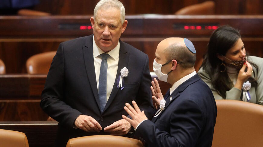 Israel's Defence Minister Benny Gantz (L) and Prime Minister Naftali Bennett speak to each other at a Knesset (parliament) meeting during which Isaac Herzog, a veteran of Israel's left-wing Labor party, was sworn in as the Jewish state's 11th president, replacing Reuvin Rivlin, in Jerusalem, on July 7, 2020.