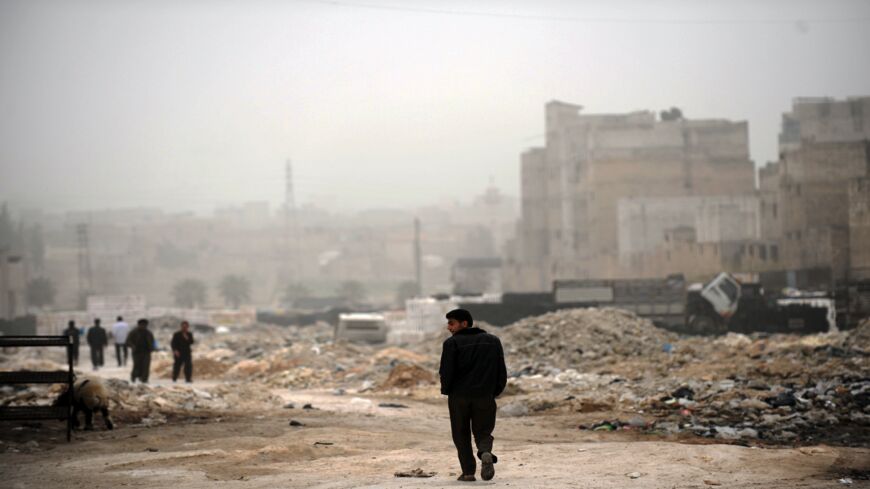 A Syrian man walks past destruction in the northern city of Aleppo on March 22, 2013.