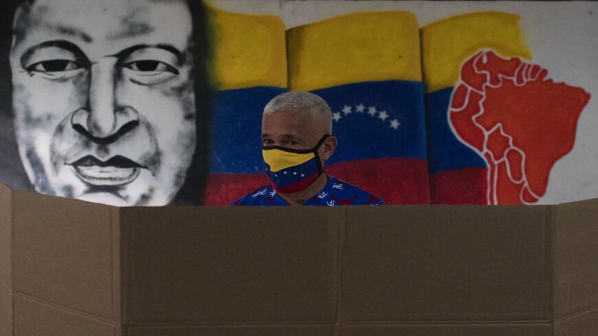 A man wearing a face mask prepares his ballot at a polling station in Caracas during the regional and municipal elections in Venezuela, on Nov. 21, 2021.