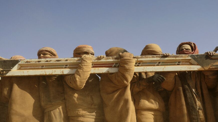 Men standing in the back of a truck after fleeing battles between SDF and IS in the Syrian village of Baghuz arrive after crossing a desert to a region controlled by the SDF in Deir ez-Zor on Jan. 26, 2019.