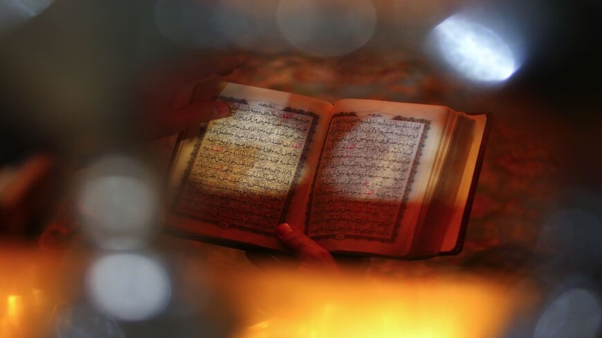 Worshippers read the Quran during prayer rituals at the Imam Ali shrine in the holy Iraqi city of Najaf, on May 1, 2021. 