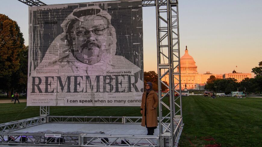 Turkish writer Hatice Cengiz (R), fiancee of Saudi journalist and dissident Jamal Khashoggi, poses next to a portrait of Khashoggi.