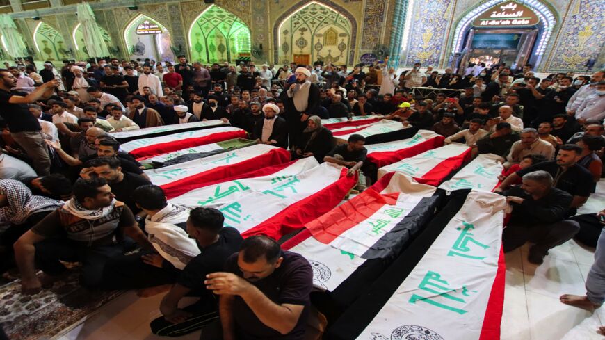 Mourners on Oct. 27, 2021, surround caskets of victims of yesterday's IS attack on the village of Al-Rashad in Iraq's eastern Diyala province. 