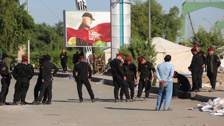 Security forces loyal to Iraq's Hashid al-Shaabi paramilitary network stand next to a protest camp set up by network supporters near the Green Zone of the capital, Baghdad, on Nov. 6, 2021.