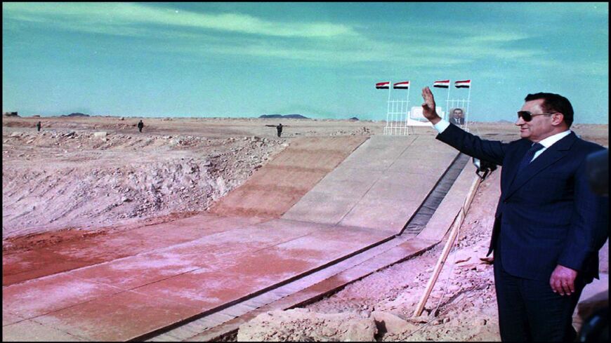 Egyptian President Hosni Mubarak in front of a new canal.