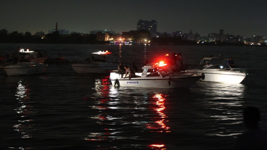 Rescuers search for victims in Cairo, Egypt, on July 23, 2015, where at least 21 people were killed after a cargo boat collided with a ferry on the Nile River.