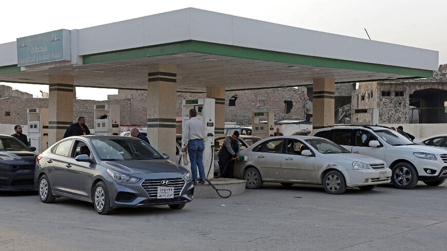 Iraqis wait in a queue at a petrol station in the northern city of Mosul to fill up their cars amid shortages authorities say are due to smuggling to neighbouring Kurdistan