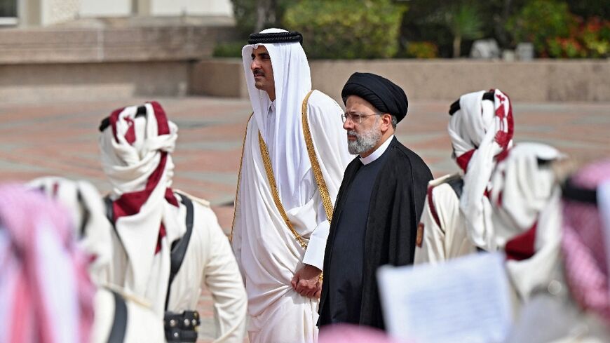 Qatar's Emir Sheikh Tamim bin Hamad al-Thani (L) received Iranian President Ebrahim Raisi at the airport