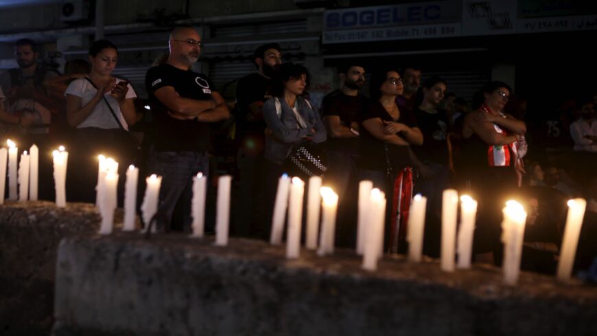 Lebanese anti-government protesters take part in a candlelight vigil outside the headquarters of Lebanon Electricity company in Beirut on Nov. 11, 2019.