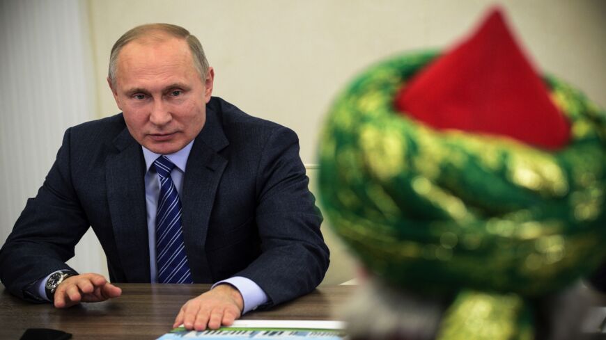 Russian President Vladimir Putin (L) talks to Russia's Chief Mufti Talgat Tadzhuddin (back) during their meeting in Kazan on Jan. 24, 2018. 