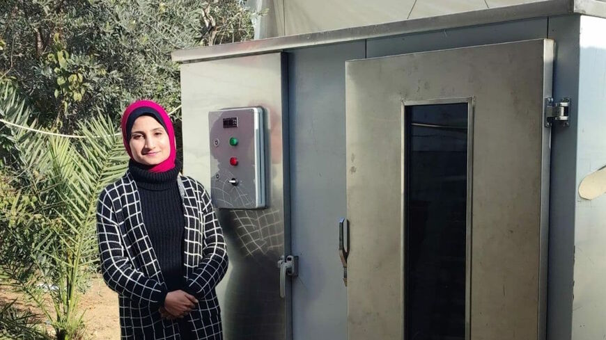 Hanadi Abu Harbid stands next to the food dehydrator.