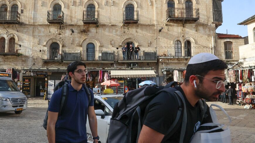 Israeli settlers walk past the Petra Hotel at the Jaffa gate area in Jerusalem's old city -- Greek Orthodox leaders denounced what the Church called the "illegal" takeover of the hotel by Israeli "extremists"