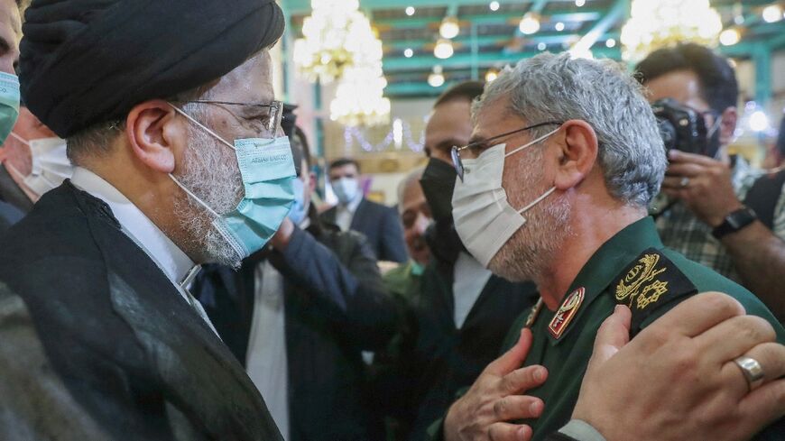 Iran's President Ebrahim Raisi (L) greets the head of the Revolutionary Guards' Quds Force Brigadier General Esmail Qaani at a Tehran ceremony to honour the families of those killed in the 1980-1988 Iran-Iraq war and veterans of that conflict