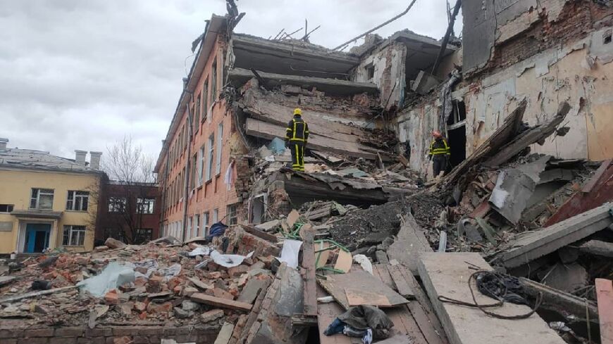 This handout picture taken and released by the Ukrainian State Emergency Service on March 7, 2022, shows rescuers dismantling the rubble of a destroyed school after Russian troops shelled the city of Chernihiv