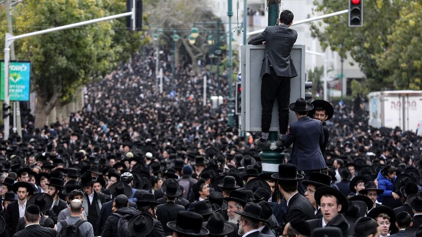 Ultra-Orthodox Jewish men walk in the funeral procession of rabbi Chaim Kanievsky in the Israeli city of Bnei Brak near Tel Aviv